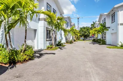 a street with palm trees in front of white buildings at Sistrunk Shades Villas Units #1 & #2 Combined in Fort Lauderdale