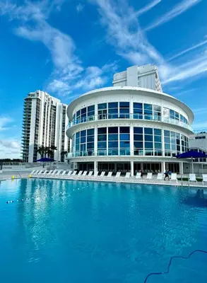 a building with a pool in front of it at Beachfront Property Pool Gym Tennis Miami Beach! in Miami Beach