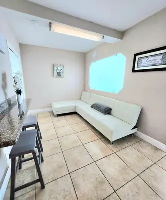 a living room with a white couch and a table at Beachfront Property Pool Gym Tennis Miami Beach! in Miami Beach