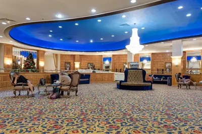 a lobby with people sitting in chairs and a christmas tree at Beachfront Property Pool Gym Tennis Miami Beach! in Miami Beach