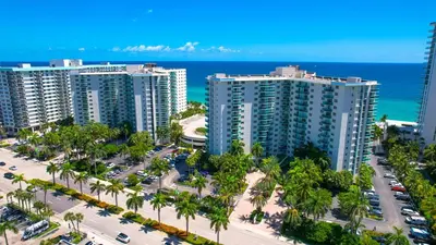 an aerial view of a resort with palm trees and the ocean at Tides Ocean Retreat by Cielo Stays in Hollywood