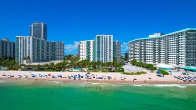 a beach with a group of people and buildings at Tides Ocean Retreat by Cielo Stays in Hollywood