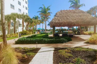 a resort with a straw hut and palm trees at Tides Ocean Retreat by Cielo Stays in Hollywood