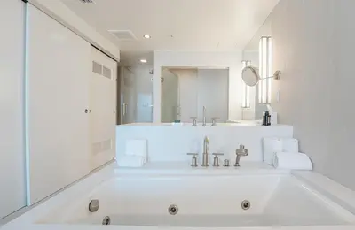 a white bathroom with a sink and a mirror at Beachfront-Spacious W Residence in Fort Lauderdale