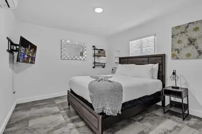 a white bedroom with a bed and a table at Lovely 2 bedroom Studios-Suite Walking Distance To Ocean in Hollywood