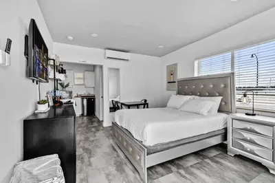 a bedroom with a large bed and a kitchen at Lovely Studio Walking Distance To Ocean - Suite 5 in Hollywood