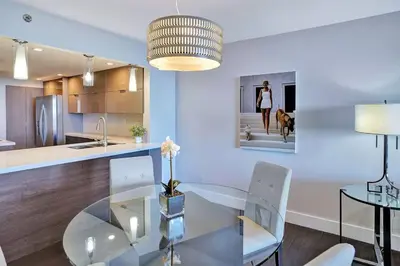 a kitchen with a glass table and white chairs at Miami Vibes! Biscayne Bay Water and Park Views! in Miami