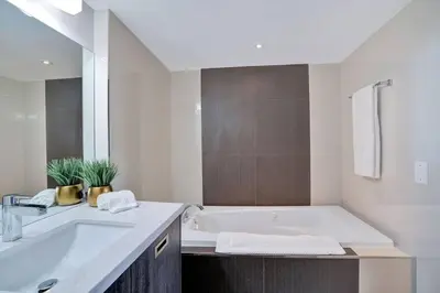 a white bathroom with a tub and a sink at Miami Vibes! Biscayne Bay Water and Park Views! in Miami