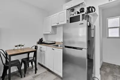a kitchen with a stainless steel refrigerator and a table at Lovely Studio Walking Distance To Ocean - Suite 7 in Hollywood