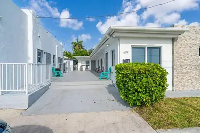 a white house with blue chairs in front of it at Lovely Studio Walking Distance To Ocean - Suite 8 in Hollywood