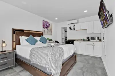 a bedroom with a large bed and a kitchen at Lovely Studio Walking Distance To Ocean - Suite 8 in Hollywood