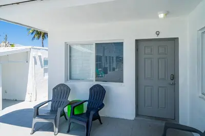 two chairs and a table on a porch with a door at Lovely 1 Bedroom Walking Distance To Ocean - Suite 9 in Hollywood