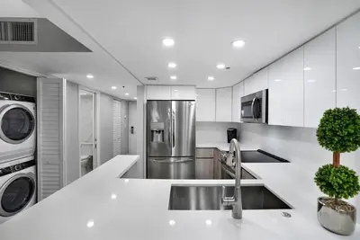 a white kitchen with a sink and a dishwasher at Calypso - Gorgeous Miami Renovated Spacious Condo! in Miami