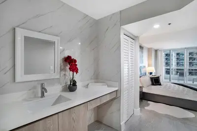 a white bathroom with a sink and a bed at Calypso - Gorgeous Miami Renovated Spacious Condo! in Miami
