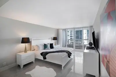 a white bedroom with a bed and a television at Shock Wave! NEW Renovated Condo With Water Views! in Miami