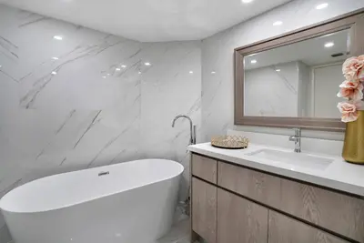 a bathroom with a tub and a sink and a mirror at Shock Wave! NEW Renovated Condo With Water Views! in Miami