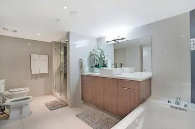 a bathroom with two sinks and a tub and a toilet at SeaDuced By Miami Skyline And Bay Views! in Miami