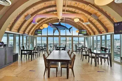 a dining room with tables and chairs and windows at Endless Summer! Incredible Water Views in Miami