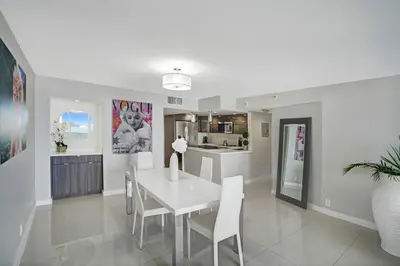 a white dining room with a white table and chairs at Sin City! Brand new and water view! in Miami