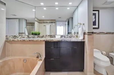 a bathroom with a tub and a toilet and a sink at Sky High Penthouse! Water & City Views (top floor) in Miami