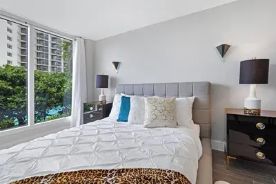 a bedroom with a bed and a large window at The Palms! Direct water view corner condo in Miami