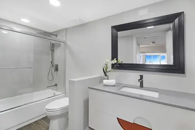 a bathroom with a toilet and a sink and a mirror at The Palms! Direct water view corner condo in Miami
