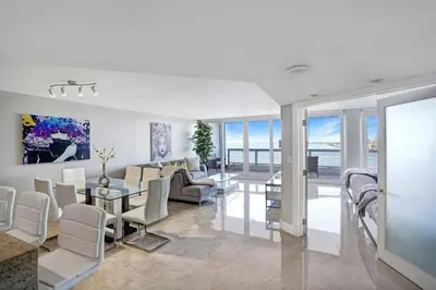 a living room with white furniture and a view of the ocean at Only in My Dreams! Direct Water View Luxury Condo in Miami