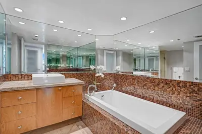 a large bathroom with a tub and a large mirror at Only in My Dreams! Direct Water View Luxury Condo in Miami