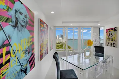 a dining room with a glass table and a view of the ocean at Walking on Water! Water Views! in Miami
