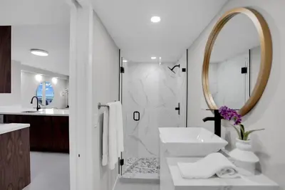a white bathroom with a sink and a mirror at Fantasy! Water & Park Views! in Miami