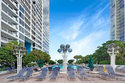 a patio with chairs and a pool and a building at Fantasy! Water & Park Views! in Miami