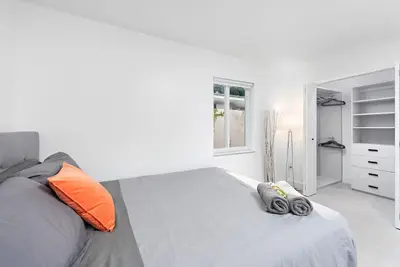 a white bedroom with a large bed with orange pillows at Beautiful Villa with heated pool Must seen! in Miami