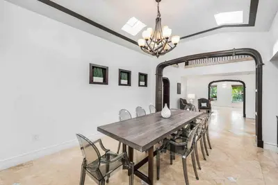 a dining room with a wooden table and chairs at Villa sleeps 18 in Miami Shores with Movie theater / Pool / Jacuzzi in Miami