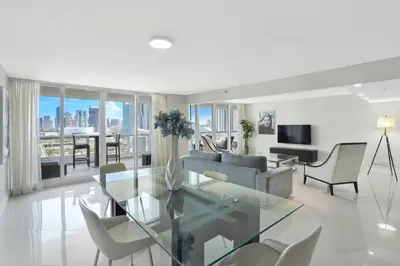 a living room with a glass table and chairs at Meet Me in Miami! Impressive Miami Skyline Views in Miami