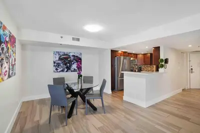 a dining room with a table and chairs and a kitchen at Aqua Marina! Water & City Views! in Miami