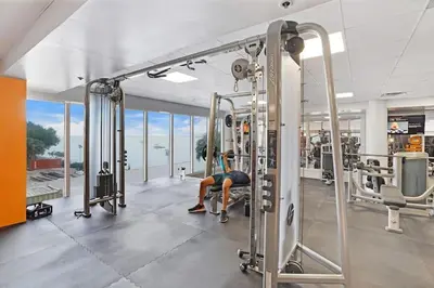 a person sitting on a bench in a gym at Over The Moon! Miami Skyline and Water Views! in Miami