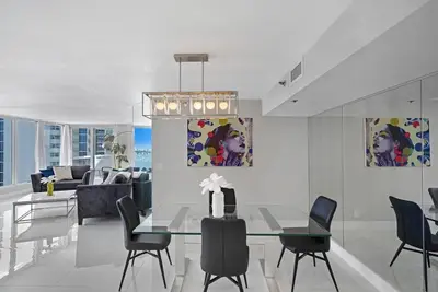 a dining room with a glass table and chairs at The Queen B! Water & Skyline Views - Renovated in Miami