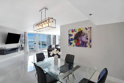 a dining room with a glass table and chairs at The Queen B! Water & Skyline Views - Renovated in Miami