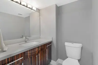 a bathroom with a sink and a toilet and a mirror at The Queen B! Water & Skyline Views - Renovated in Miami