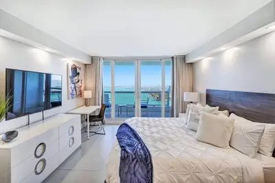 a bedroom with a large bed and a television at Sunset Hideaway! Direct Water Views and Renovated! in Miami