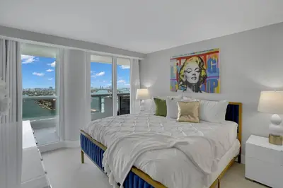 a bedroom with a large bed with a painting on the wall at Cloud Nine! Direct Water Views of Bay & Ocean! in Miami