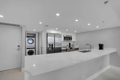a white kitchen with a large white counter top at Cloud Nine! Direct Water Views of Bay & Ocean! in Miami