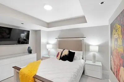 a white bedroom with a bed and two lamps at Enchanted! Miami Skyline & Water Views in Miami