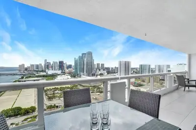 a balcony with a table and chairs and a view of the city at Enchanted! Miami Skyline & Water Views in Miami