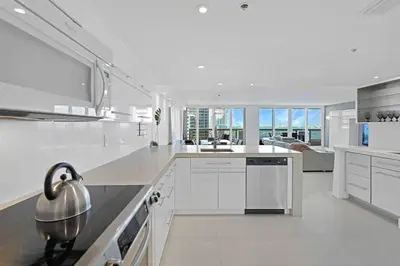 a white kitchen with white cabinets and a sink at Obsession! Water & Park Views in Miami