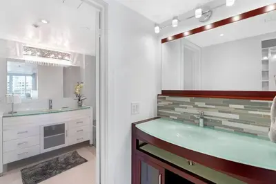 a bathroom with a sink and a large mirror at Obsession! Water & Park Views in Miami