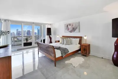 a bedroom with a bed and a large window at Classic Beauty! Skyline and water views in Miami