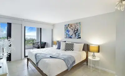 a bedroom with a bed and a large window at Shore to Please! Park And Water Views! in Miami