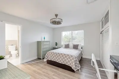 a white bedroom with a bed and a bathroom at Sunny Oasis in Hollywood