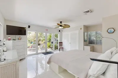 a white bedroom with a bed and a ceiling fan at Sunny Oasis in Hollywood